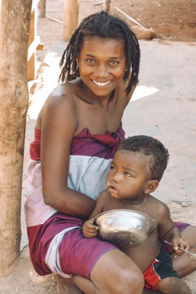 Malagasy woman with child eating rice