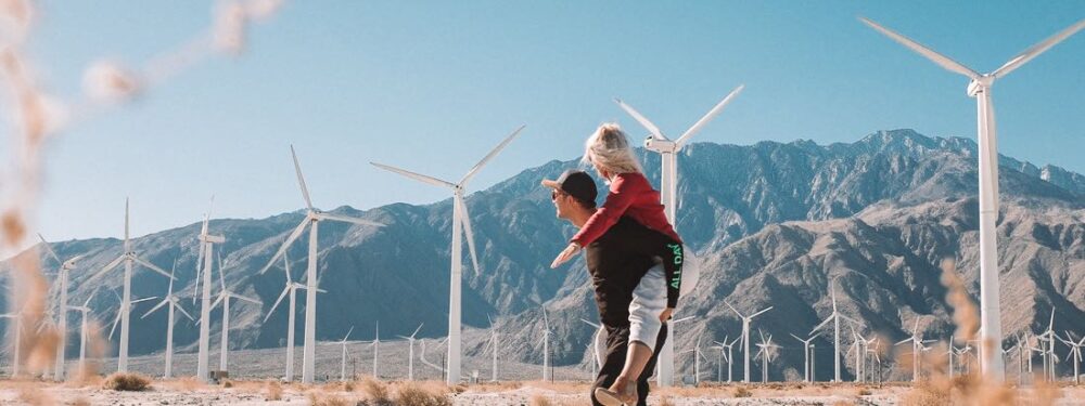 vivien and aaron at a wind turbine farm in palm springs