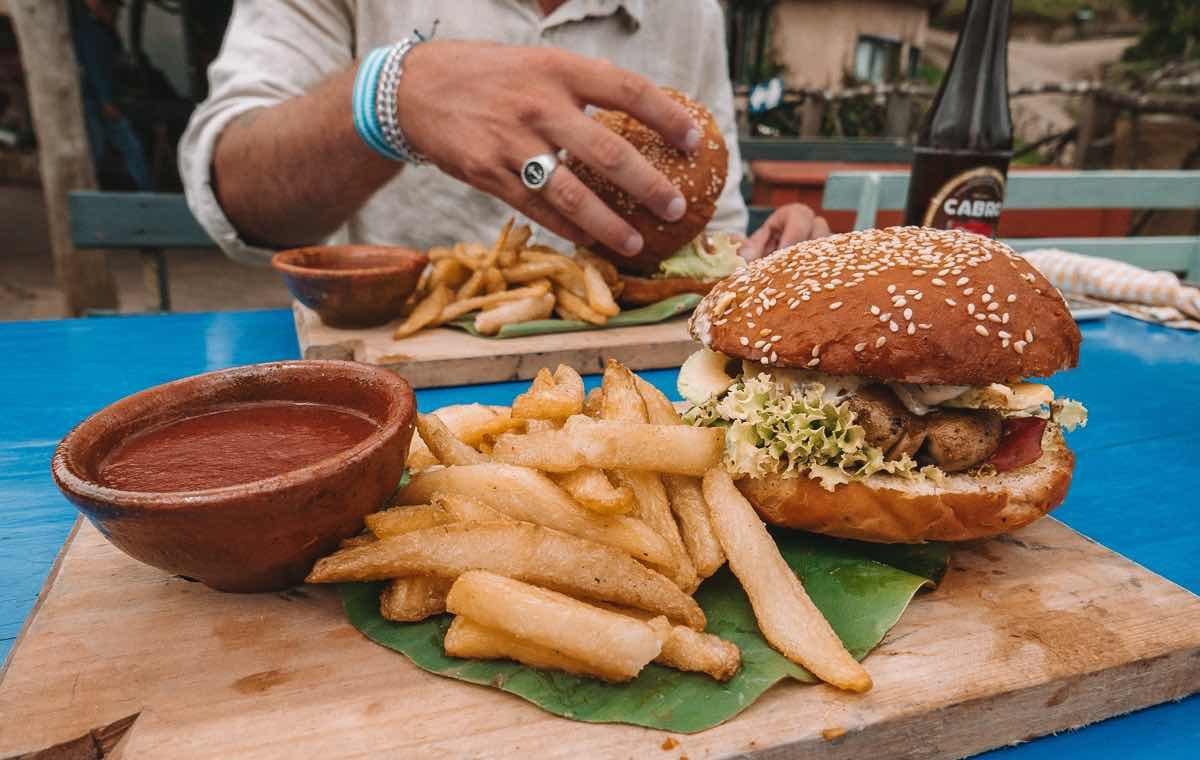 burgers and handcut fries on a wooden board on a blue table
