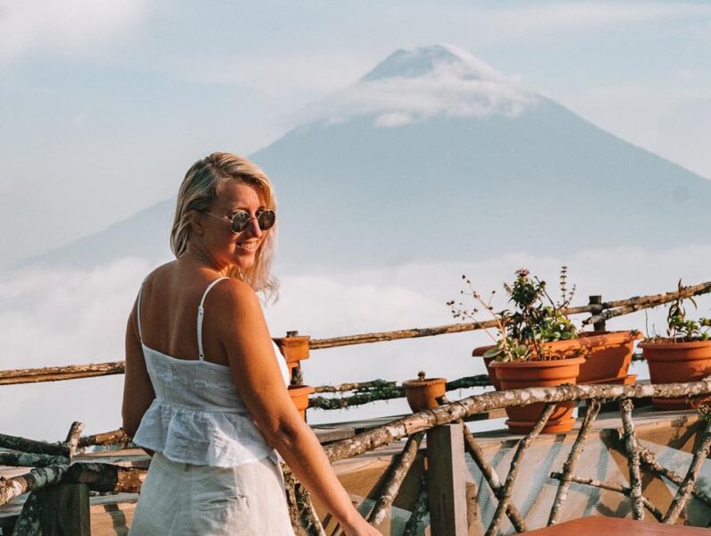 girl standing in front of a volcano in the clouds