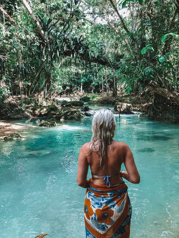 Girl wearing a sarong Standing next to blue hole in Jamaica