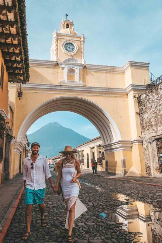 couple walking infront of the arch in antigua guatemala