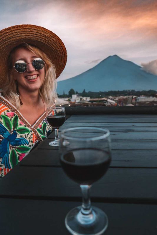rooftop bar in antigua guatemala with a volcano and sunset in the background