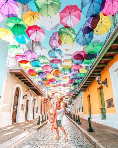 couple standing under the colourful sky umbrellas in old san juan puerto rico