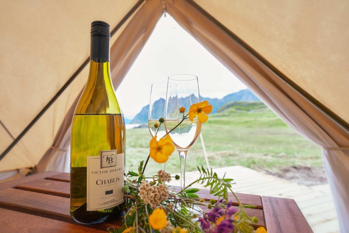 glamping bell tent with a table inside with wildflowers and white wine