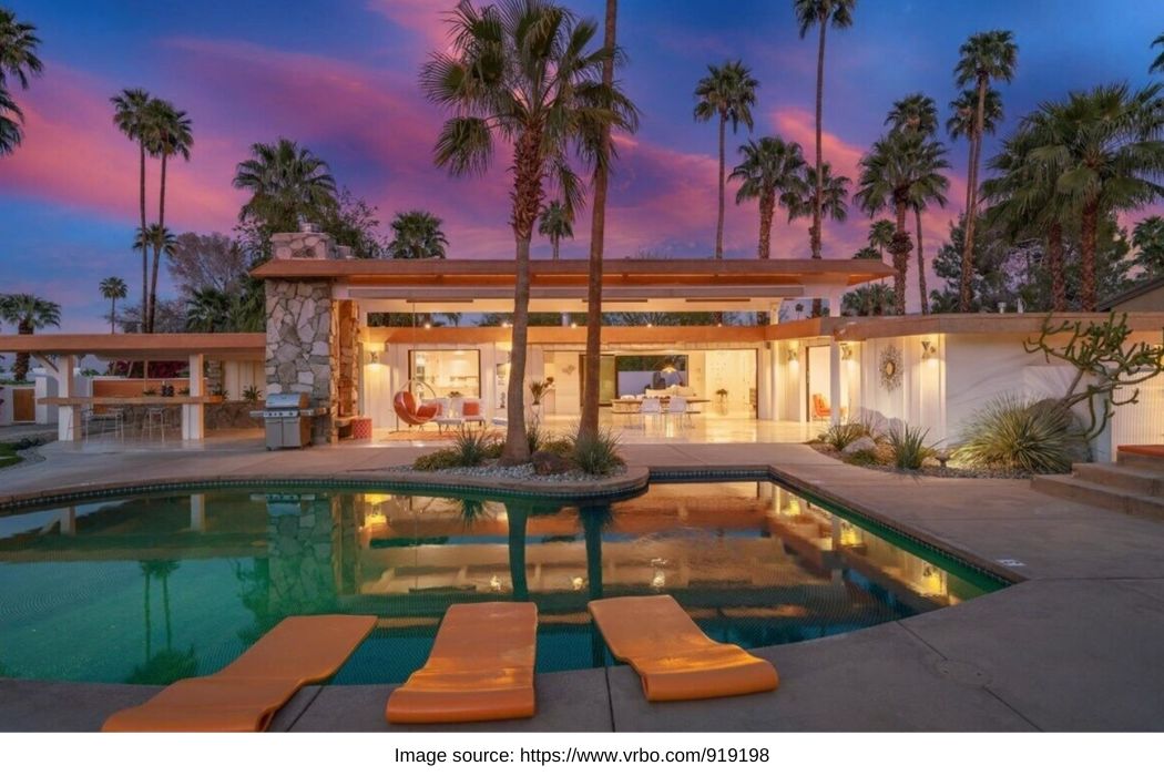 palm springs mid-century modern rental with palm trees and sunset