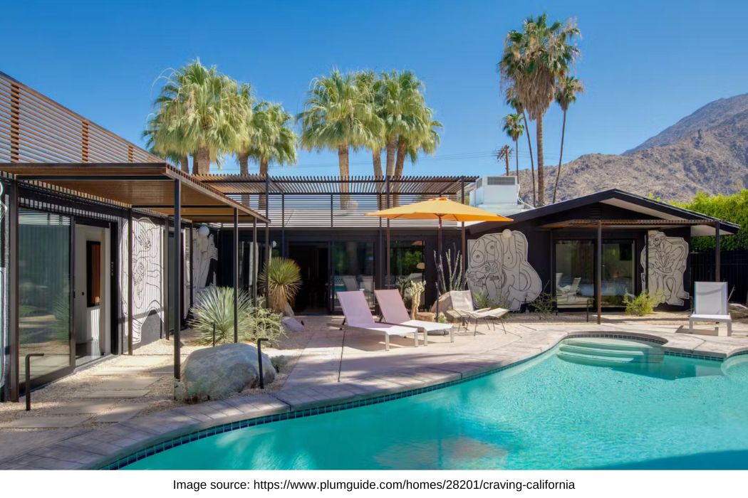 pool with a modern home in palm springs, surrounded by palm trees and the mountains