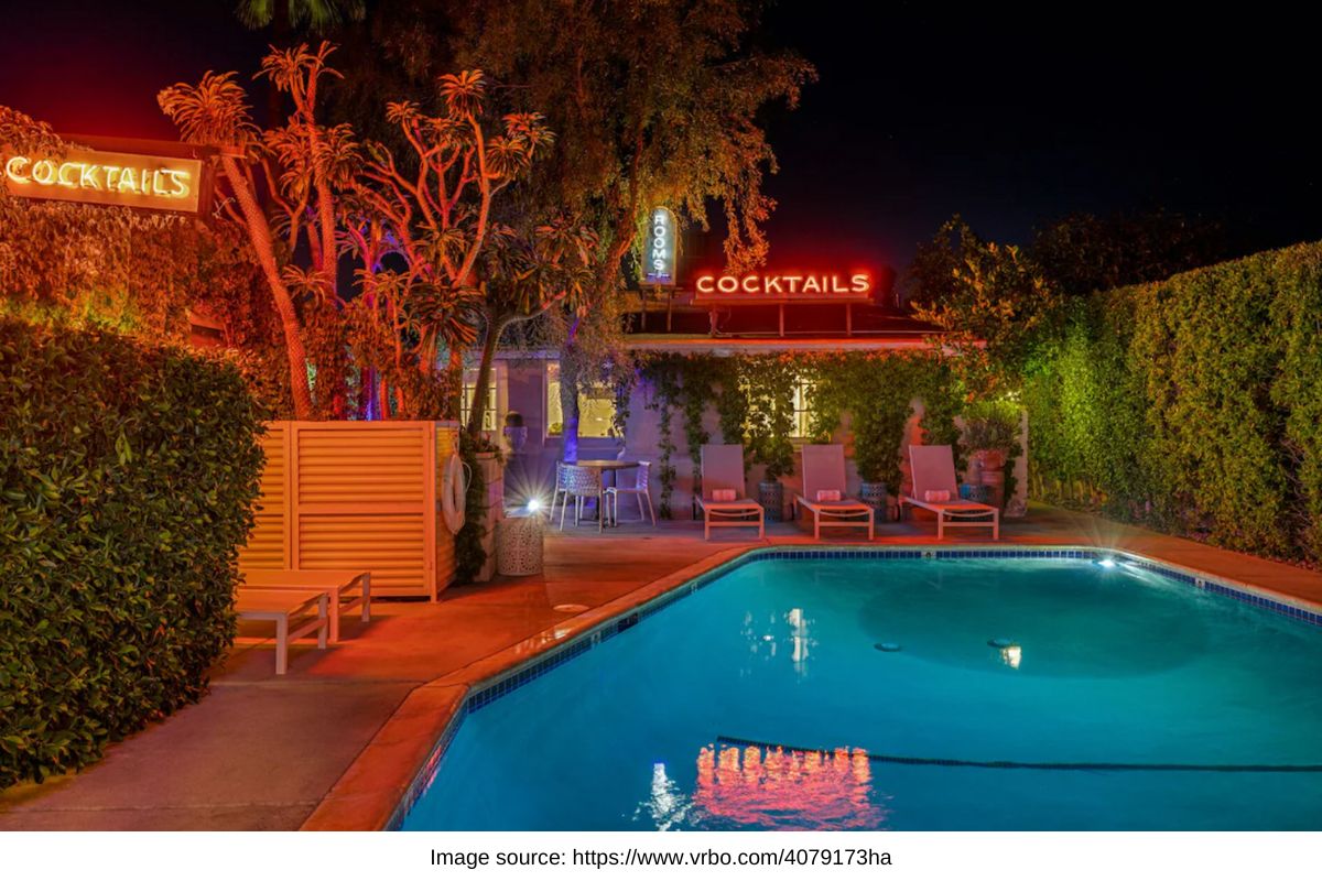 pool at night time, with neon cocktails sign