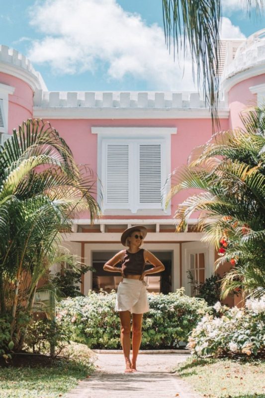 Pink Castle surrounded by tropical palm trees ( great house and pool at Cobblers Cove Barbados Boutique Resort)