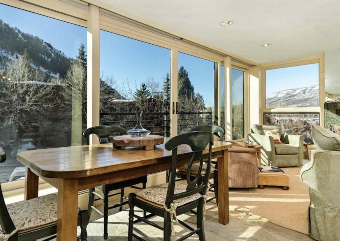 living room with glass windows overlooking aspen mountains