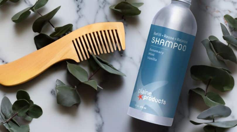 plaine productss shampoo on marble backdrop