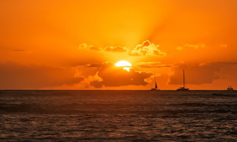 sail boats with sun setting